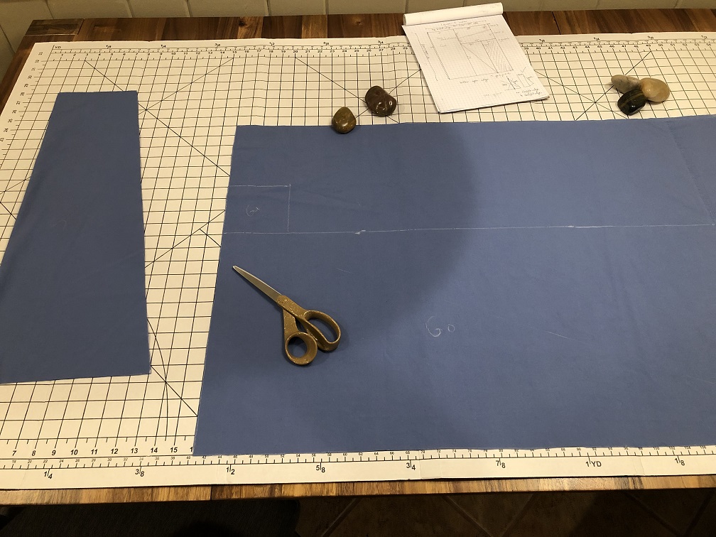 A photo of pieces of blue fabric being cut off a larger piece of fabric