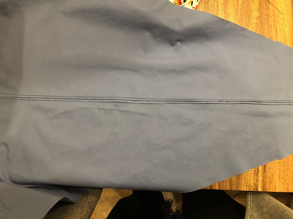 Blue fabric with the bad diagonal stitching ripped out, sewn straight, with a felled seam