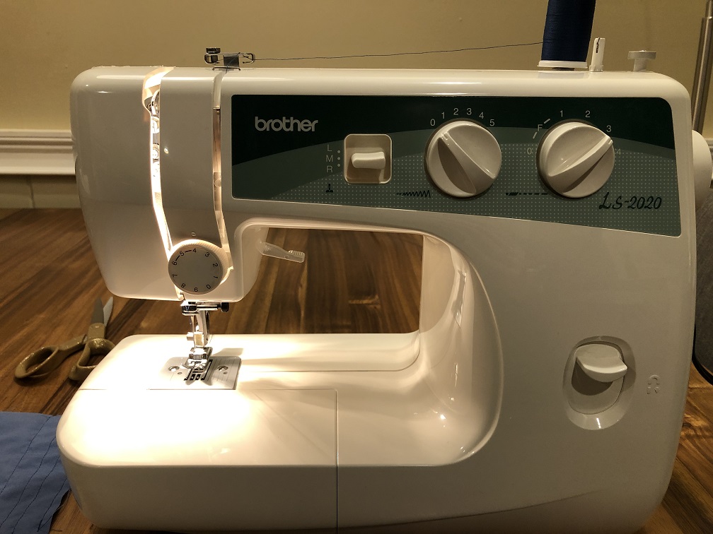 A white Brother brand sewing machine sitting on a wood table