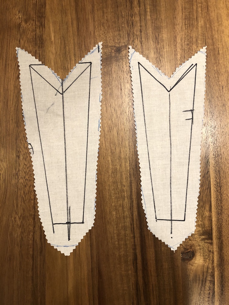 Two white pices of fabric in a shape similar to arrow tailfeathers