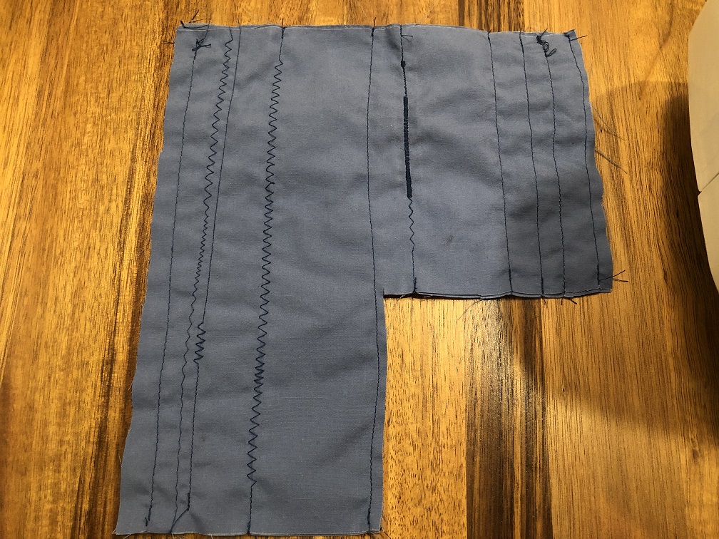 A piece of blue scrap fabric with a dozen different stitch types including zigzag, satin, and straight