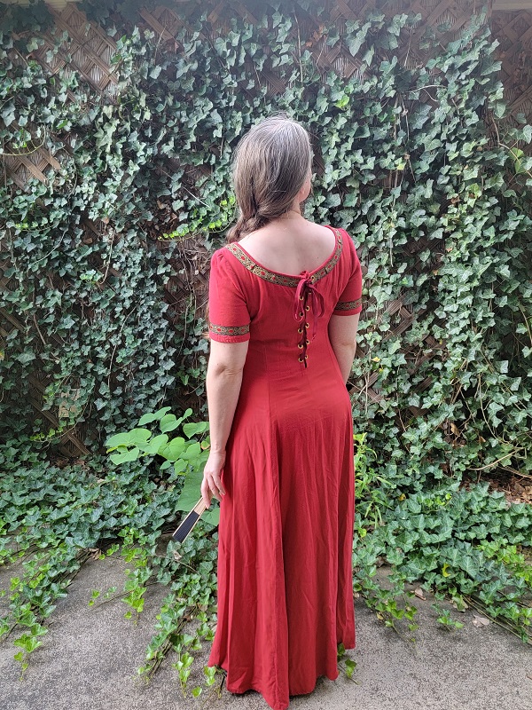 A woman wearing a red linen short sleeved dress facing away from the camera