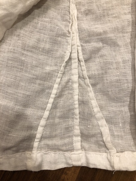 A close up of three French seams on a white linen shirt