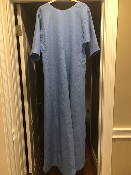 A blue short sleeved Viking dress hanging from a door frame