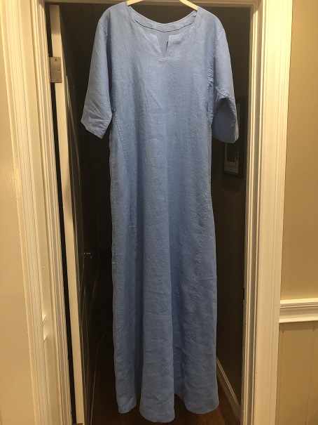 A blue short sleeved Viking dress hanging from a door frame