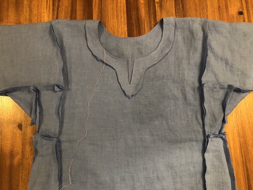 The inside of a blue Viking dress showing the seams and the unfinished neck facing