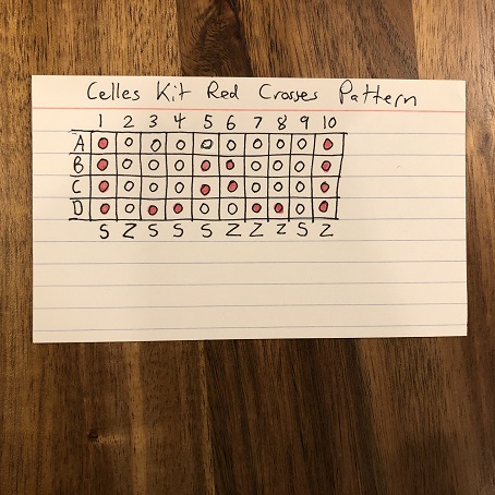 An index card that reads Celles Kit Red Crosses Pattern with a diagram of a tablet weaving pattern drawn below