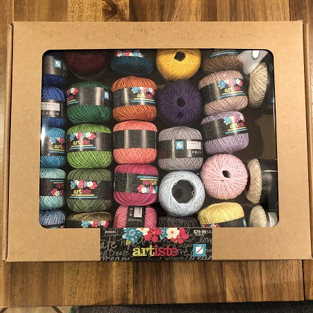 A box of 25 small spools of weaving thread in a wide variety of colors